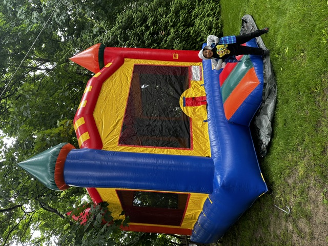Red, yellow, and blue castle bounce house with pointed inflatable towers
