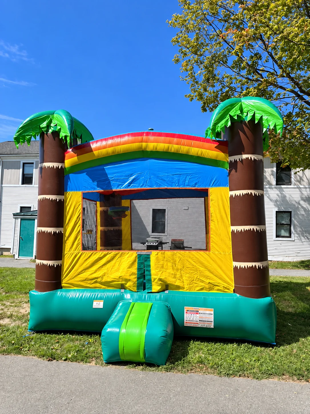 Green and yellow tropical bounce house with inflatable palm trees